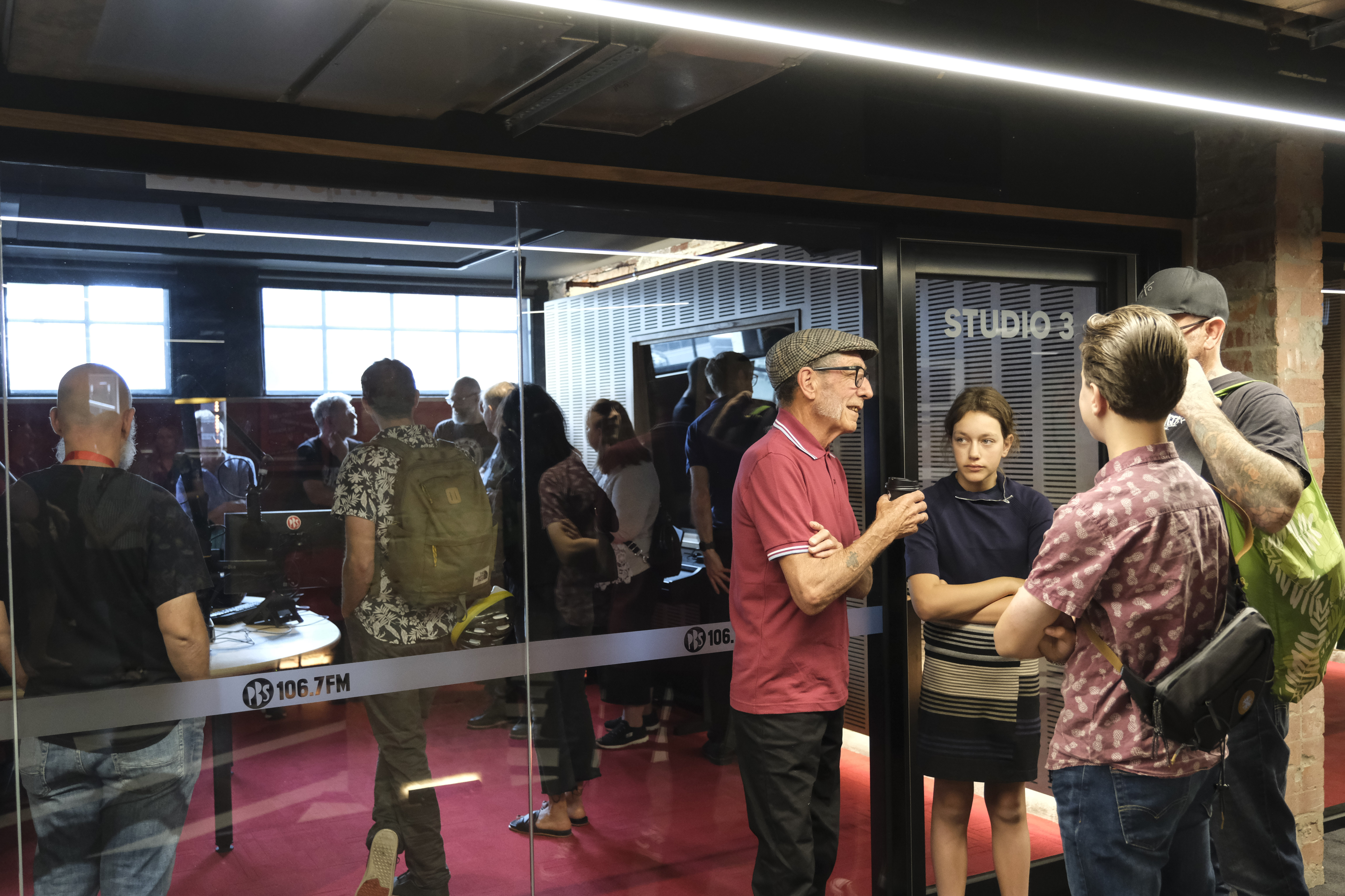 PBS Open Day 2023, Vince Peach talks with a group of visitors, whilst a tour group fills Studio 1