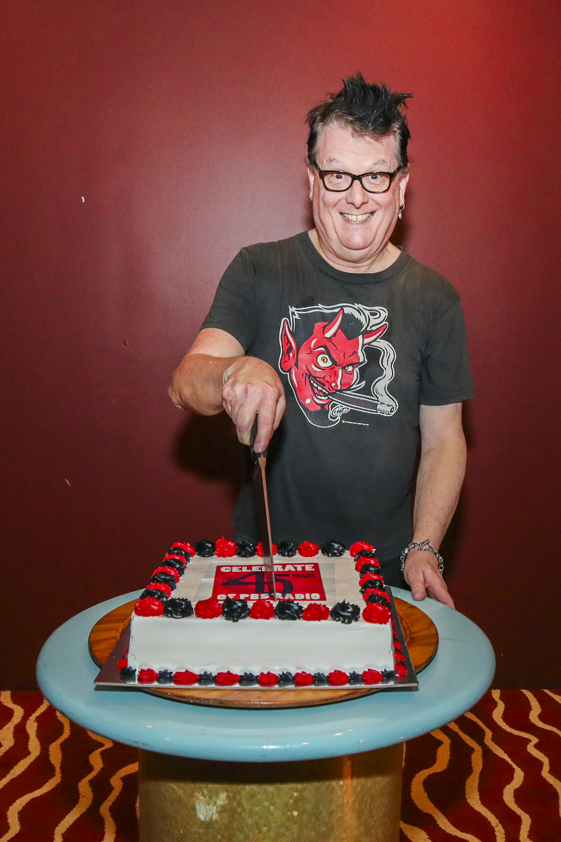 Sunglasses After Dark's Phil MacDougall cuts the celebration cake at PBS's 45th birthday Photo credit: Mauro Trentin @mauro_images